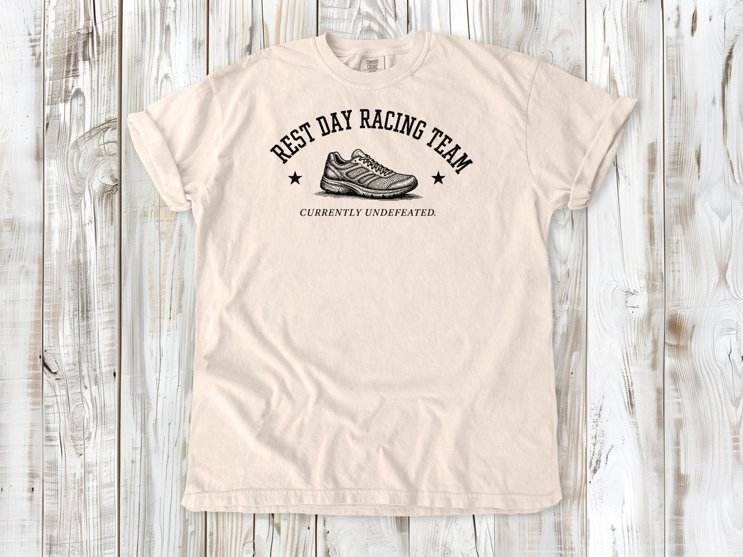Ivory garment-dyed tee with Rest Day Racing Team running humor graphic.