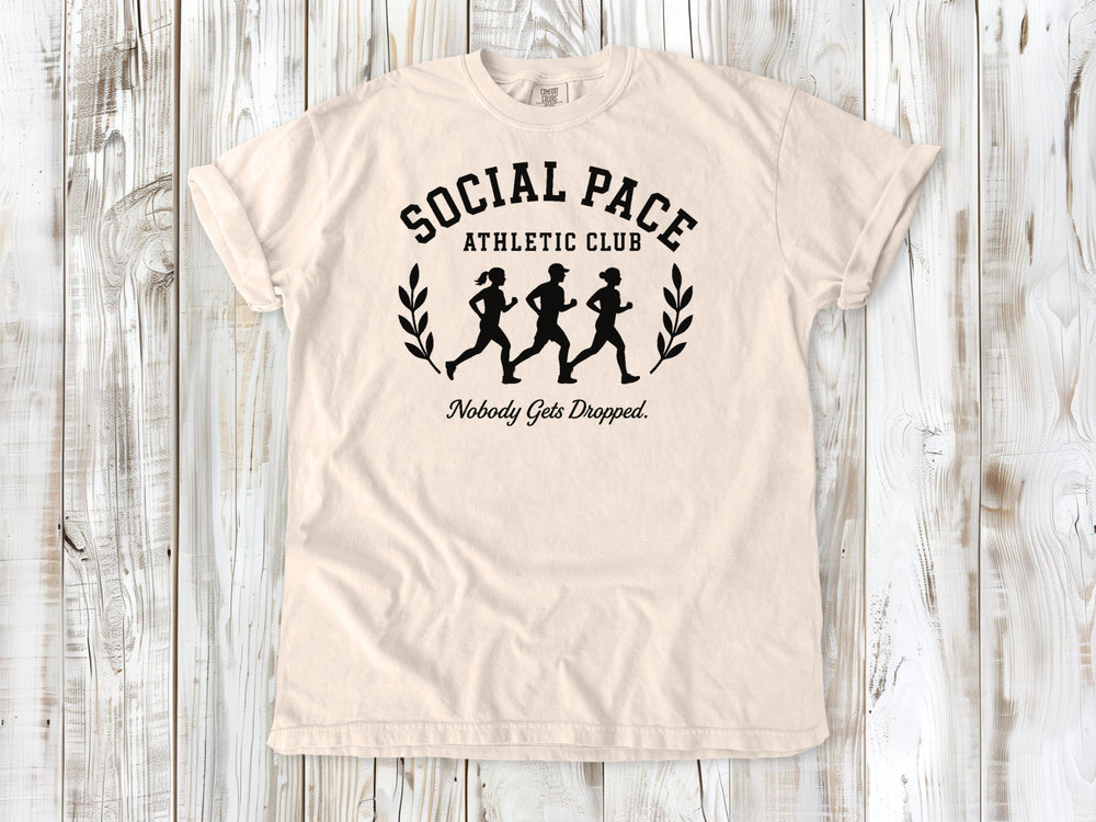 Ivory garment-dyed tee with Social Pace Athletic Club group running graphic.