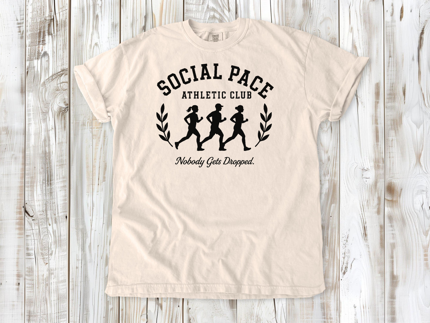 Ivory garment-dyed tee with Social Pace Athletic Club group running graphic.