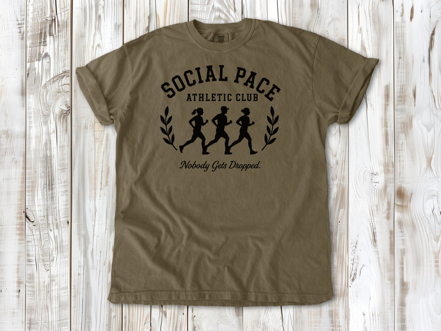 Khaki garment-dyed tee with Social Pace Athletic Club group running graphic.