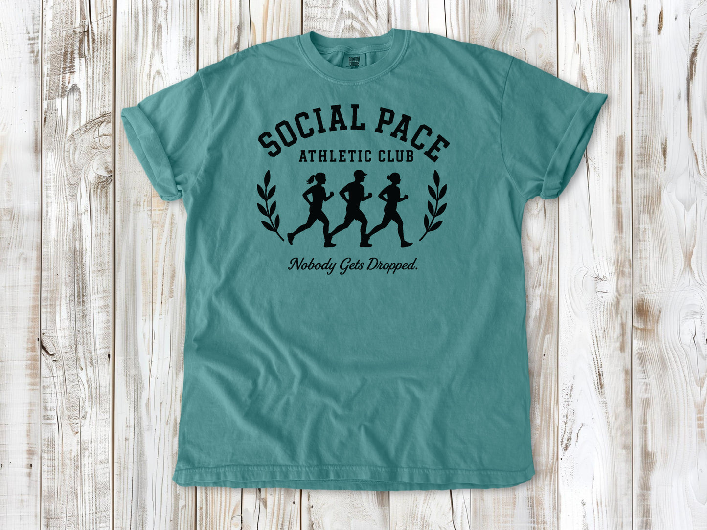 Seafoam garment-dyed tee with Social Pace Athletic Club group running graphic.