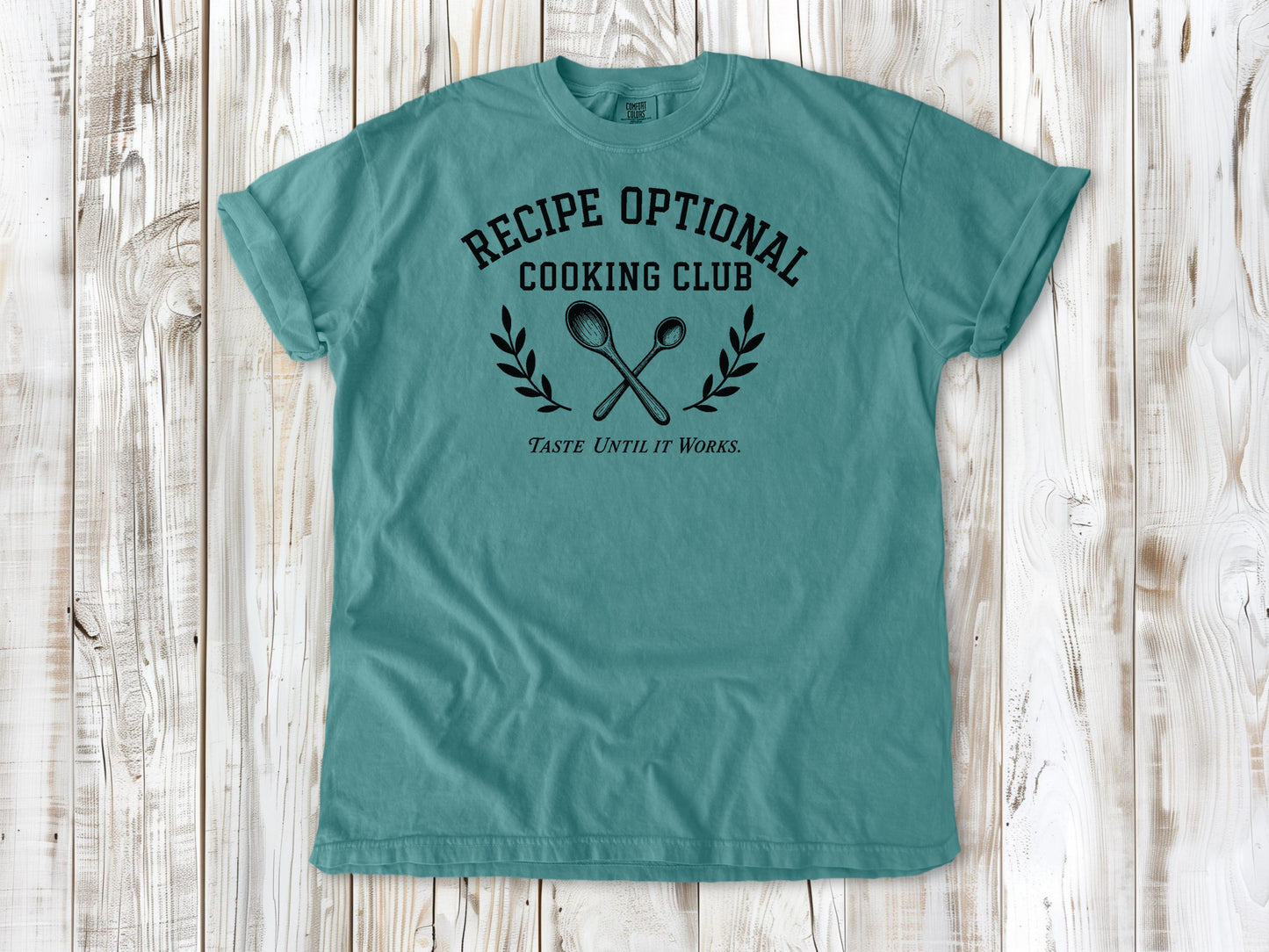 Seafoam garment-dyed tee with Recipe Optional Cooking Club kitchen graphic.