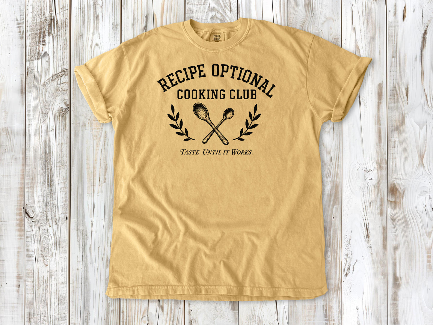Mustard garment-dyed tee with Recipe Optional Cooking Club kitchen graphic.