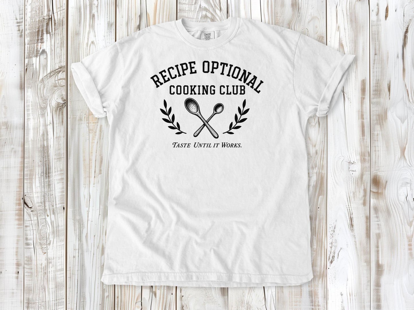 White garment-dyed tee with Recipe Optional Cooking Club kitchen graphic.