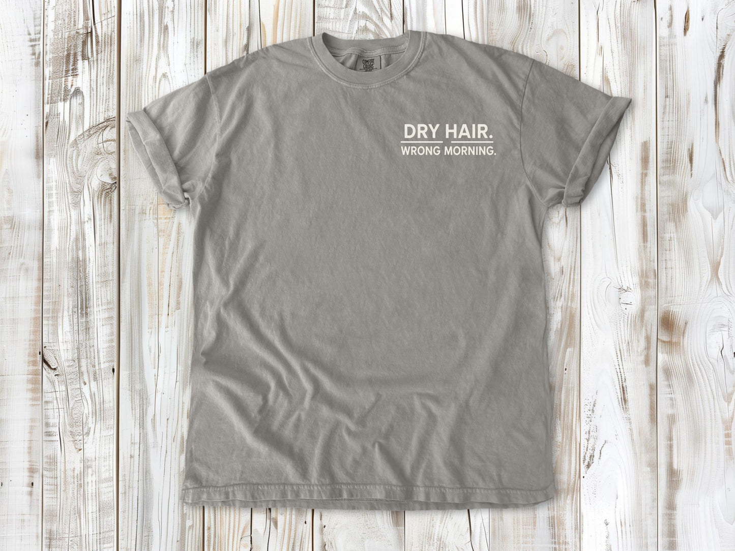 Grey garment-dyed tee with Dry Hair Wrong Morning small left-chest surf graphic.