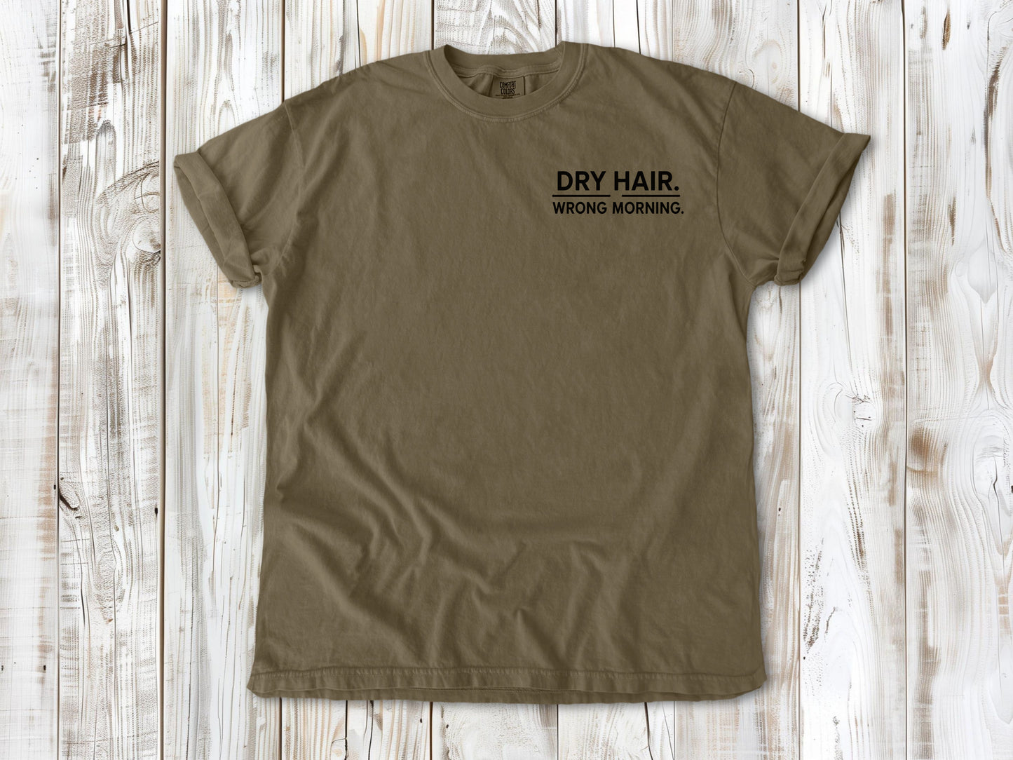 Khaki garment-dyed tee with Dry Hair Wrong Morning small left-chest surf graphic.