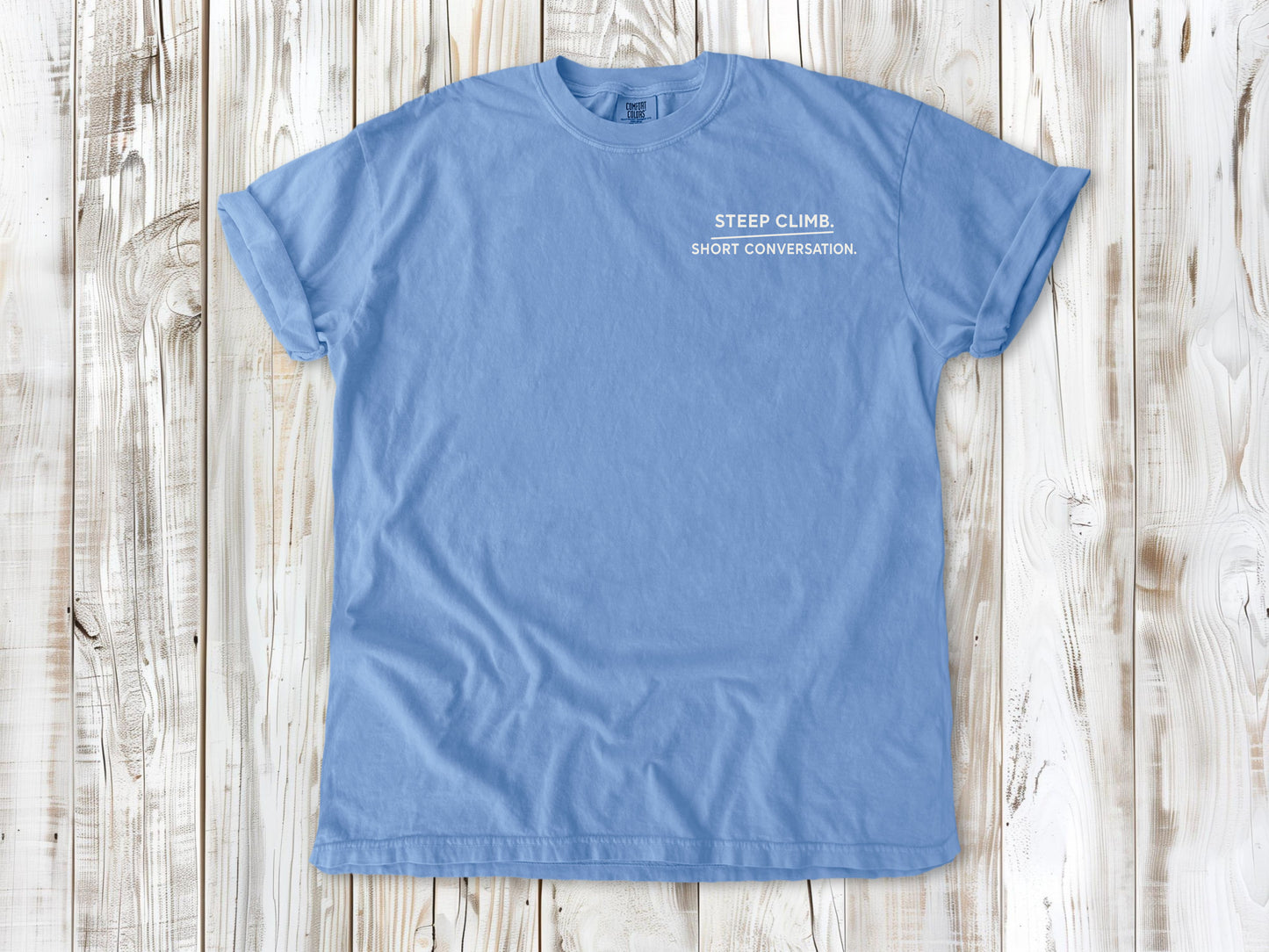 Washed Denim garment-dyed tee with Steep Climb Short Conversation small left-chest cycling graphic.