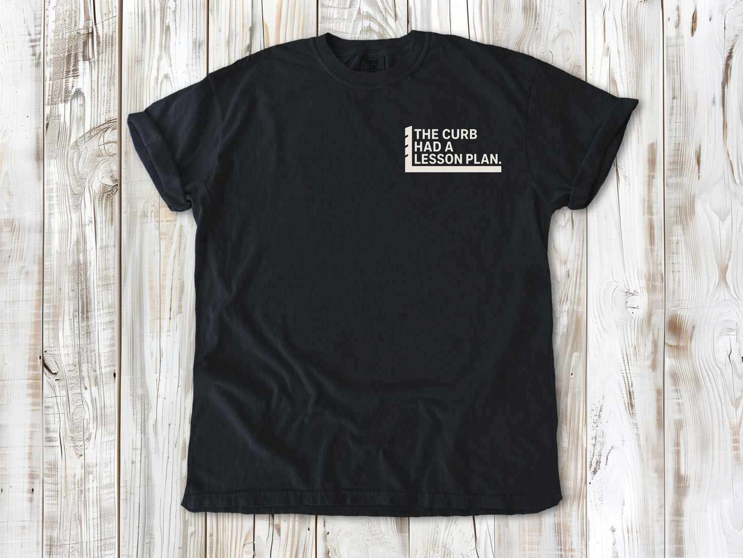 Graphite garment-dyed tee with The Curb Had a Lesson Plan small left-chest skate graphic.