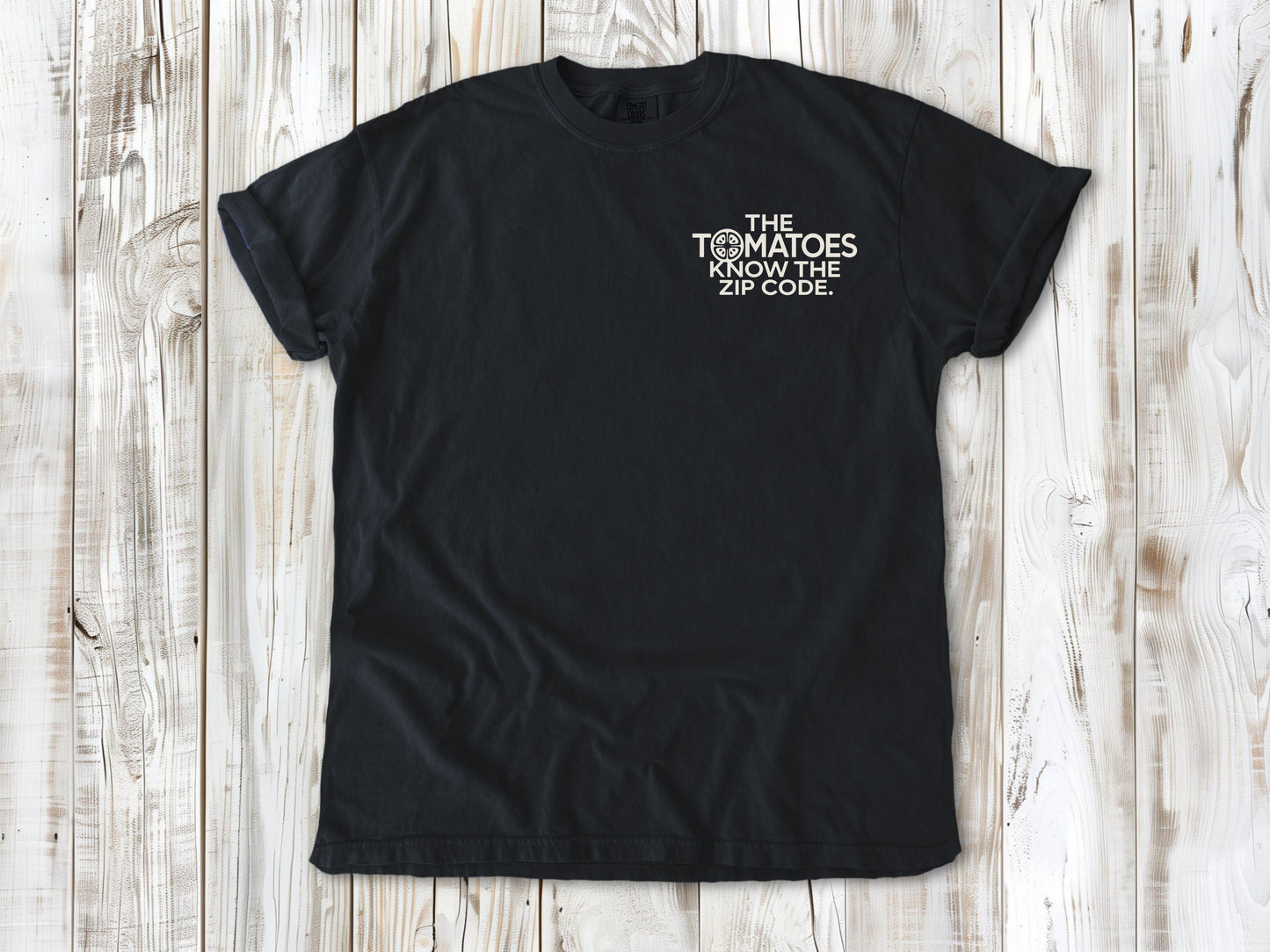 Graphite garment-dyed tee with The Tomatoes Know the Zip Code small left-chest gardening graphic.