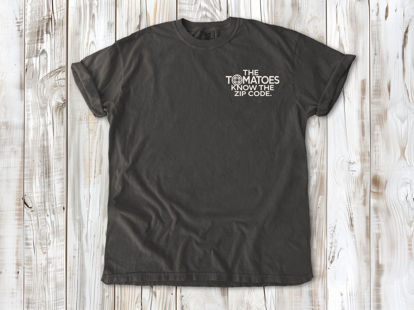 Pepper garment-dyed tee with The Tomatoes Know the Zip Code small left-chest gardening graphic.