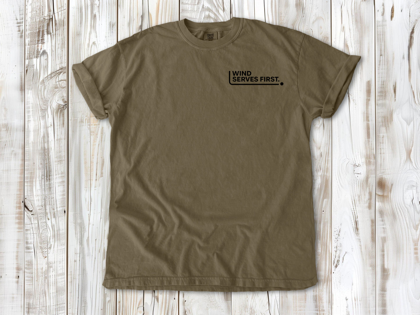Khaki garment-dyed tee with Wind Serves First small left-chest beach volleyball graphic.