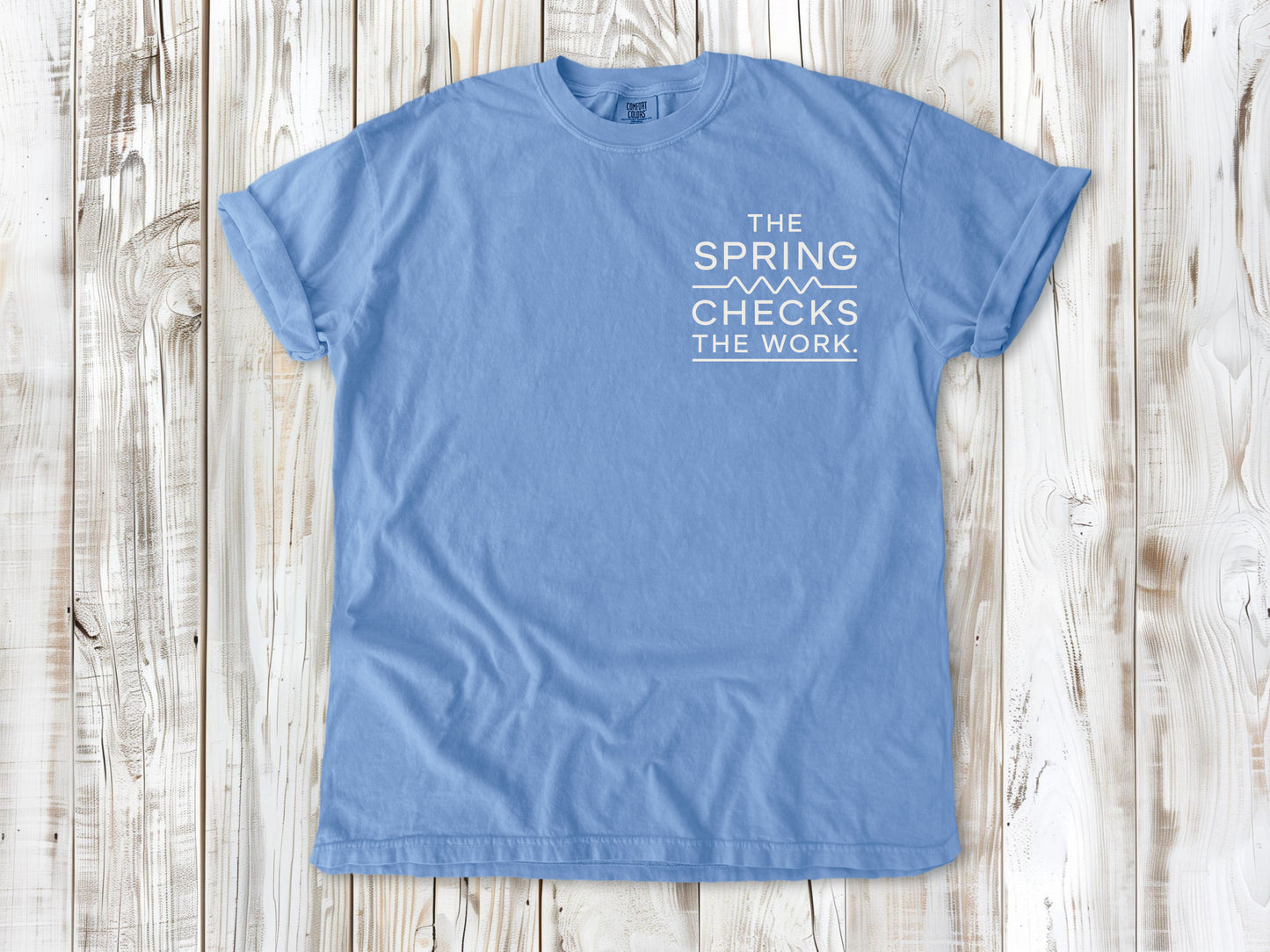 Washed Denim garment-dyed tee with The Spring Checks the Work small left-chest Pilates graphic.