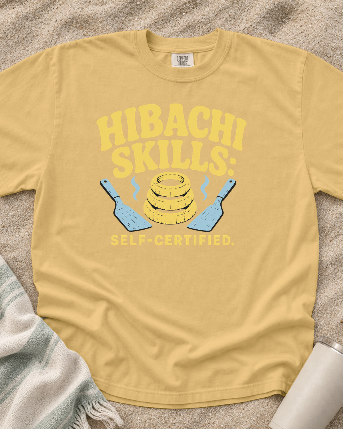 Mustard garment-dyed tee with Hibachi Skills Self-Certified griddle graphic.