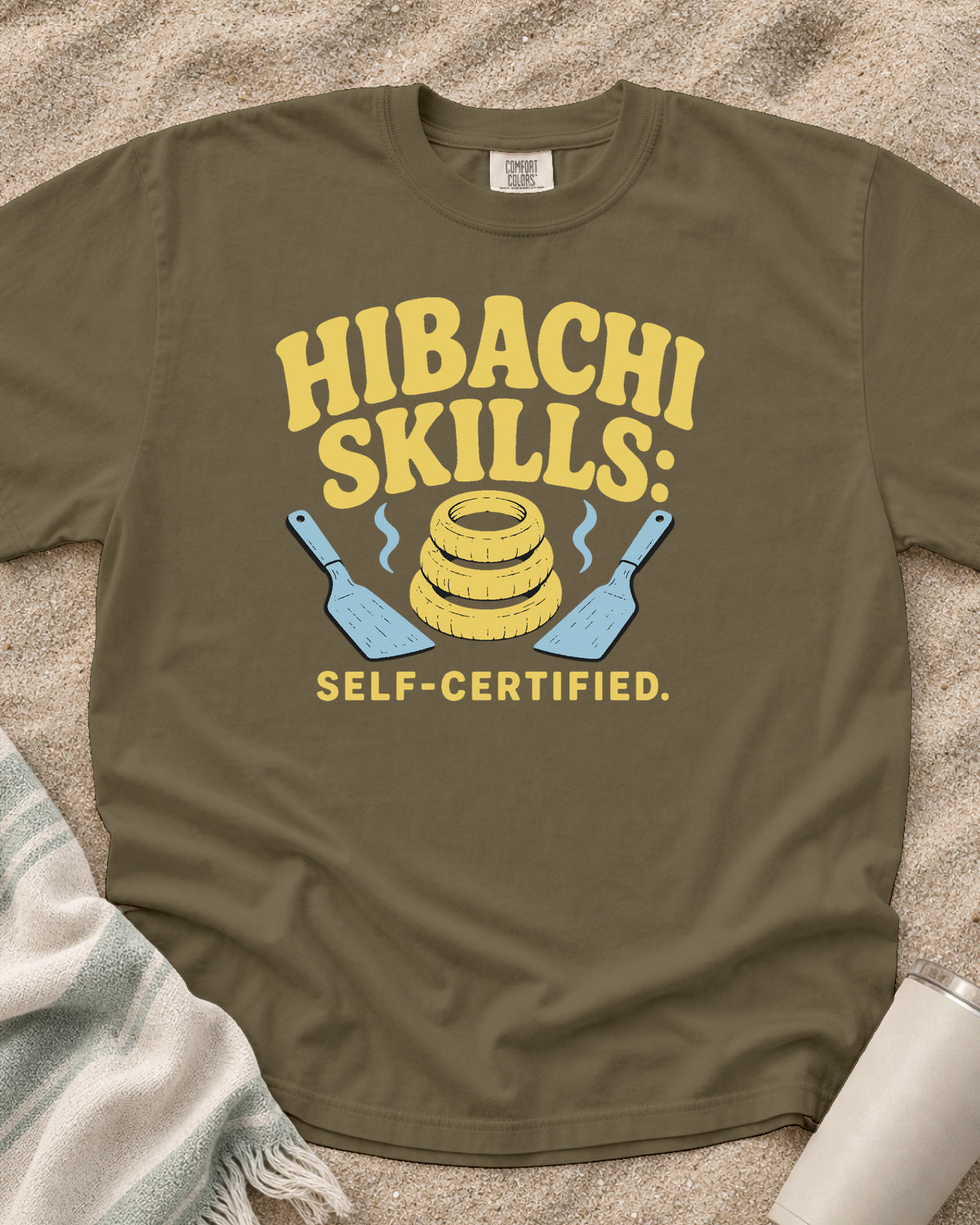 Khaki garment-dyed tee with Hibachi Skills Self-Certified griddle graphic.