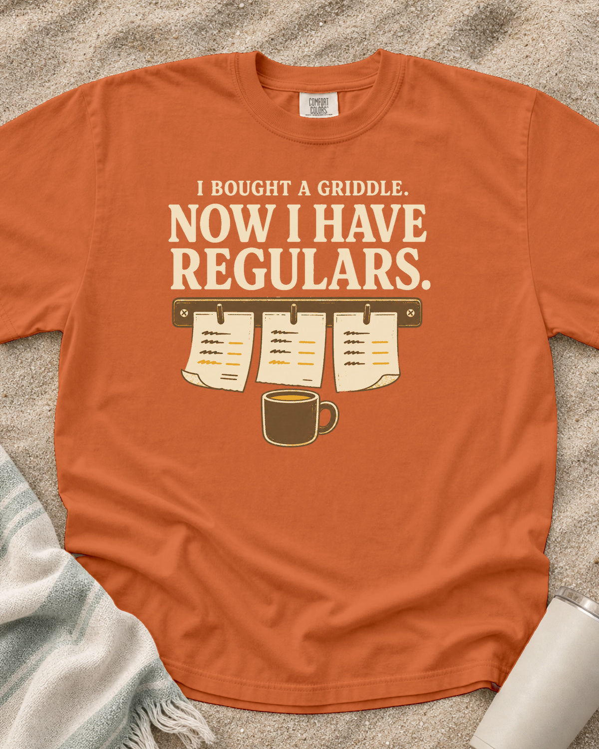 Burnt Orange garment-dyed tee with I Bought a Griddle Now I Have Regulars graphic.