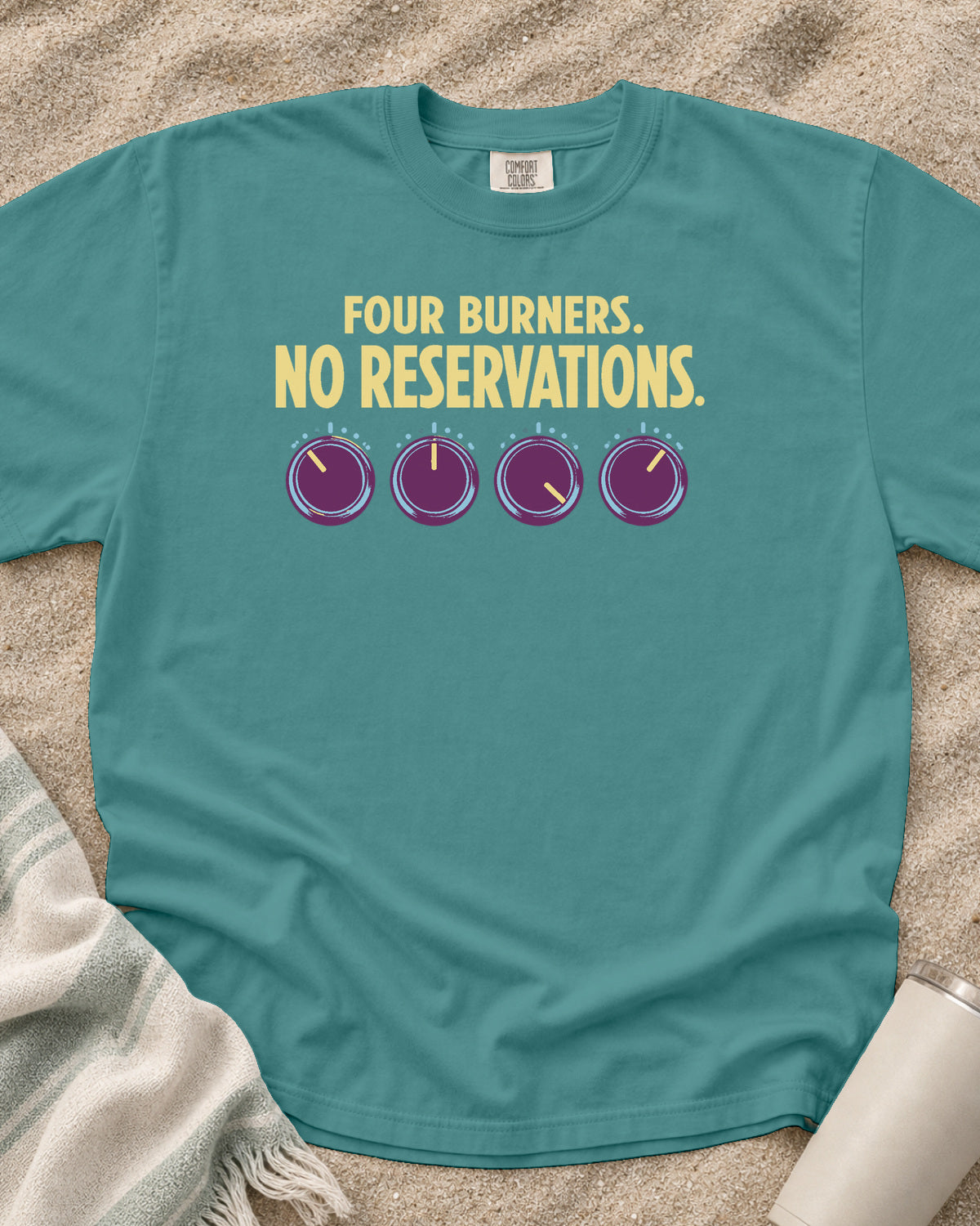 Seafoam garment-dyed tee with Four Burners No Reservations griddle graphic.