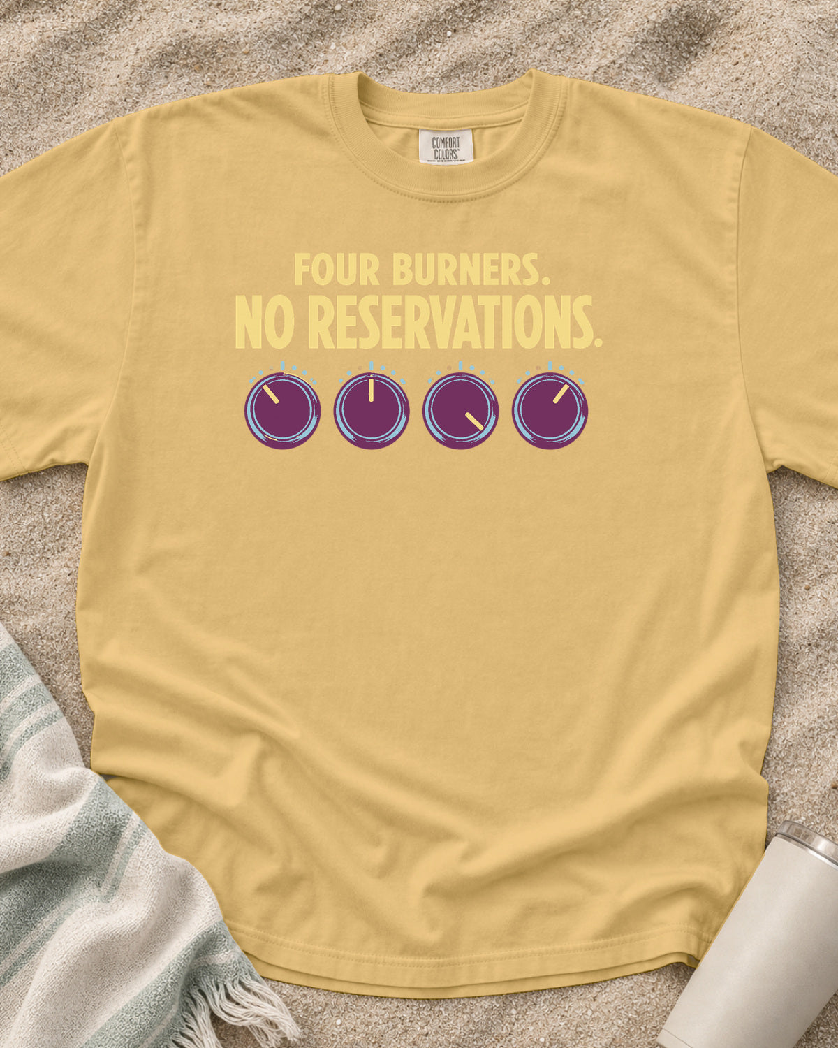 Mustard garment-dyed tee with Four Burners No Reservations griddle graphic.