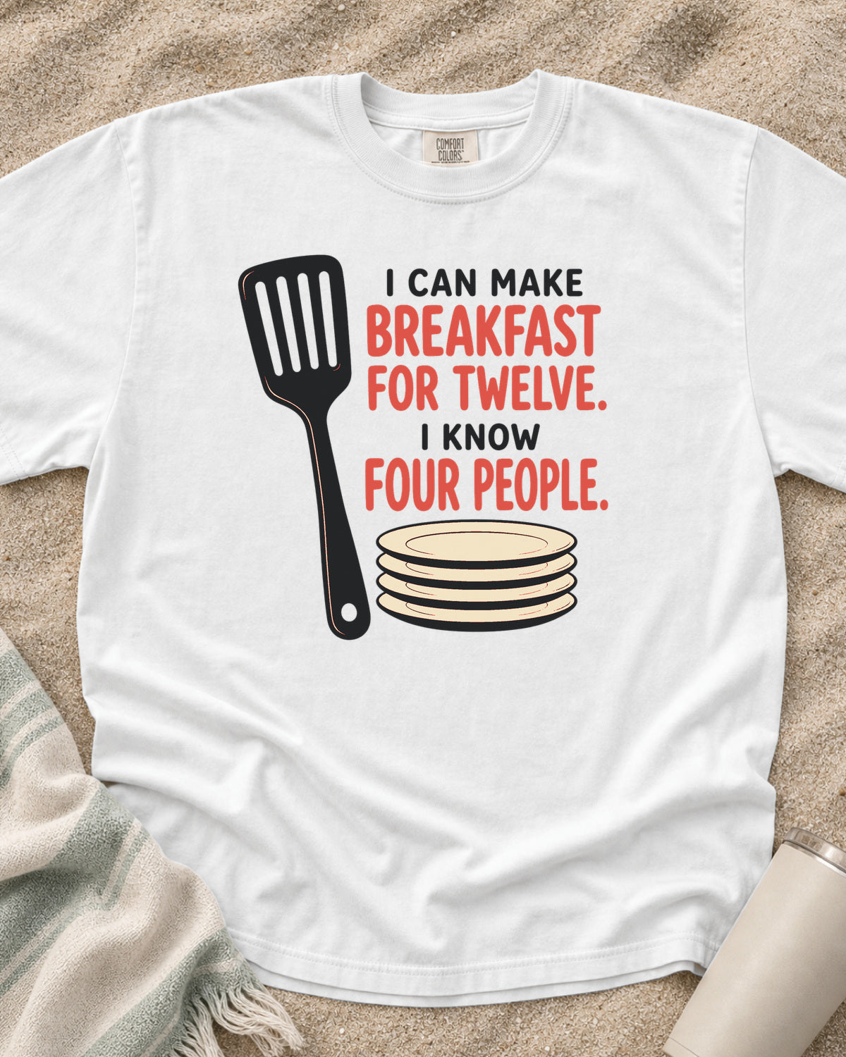 White garment-dyed tee with I Can Make Breakfast for Twelve griddle graphic.