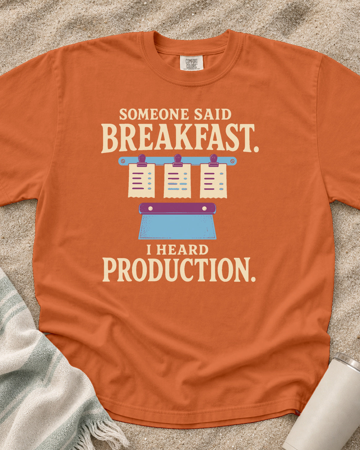 Burnt Orange garment-dyed tee with Someone Said Breakfast I Heard Production graphic.