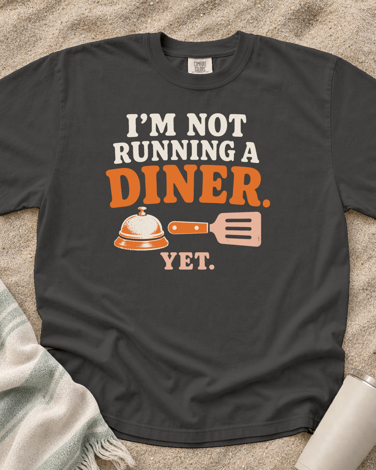 Pepper garment-dyed tee with I’m Not Running a Diner Yet griddle graphic.