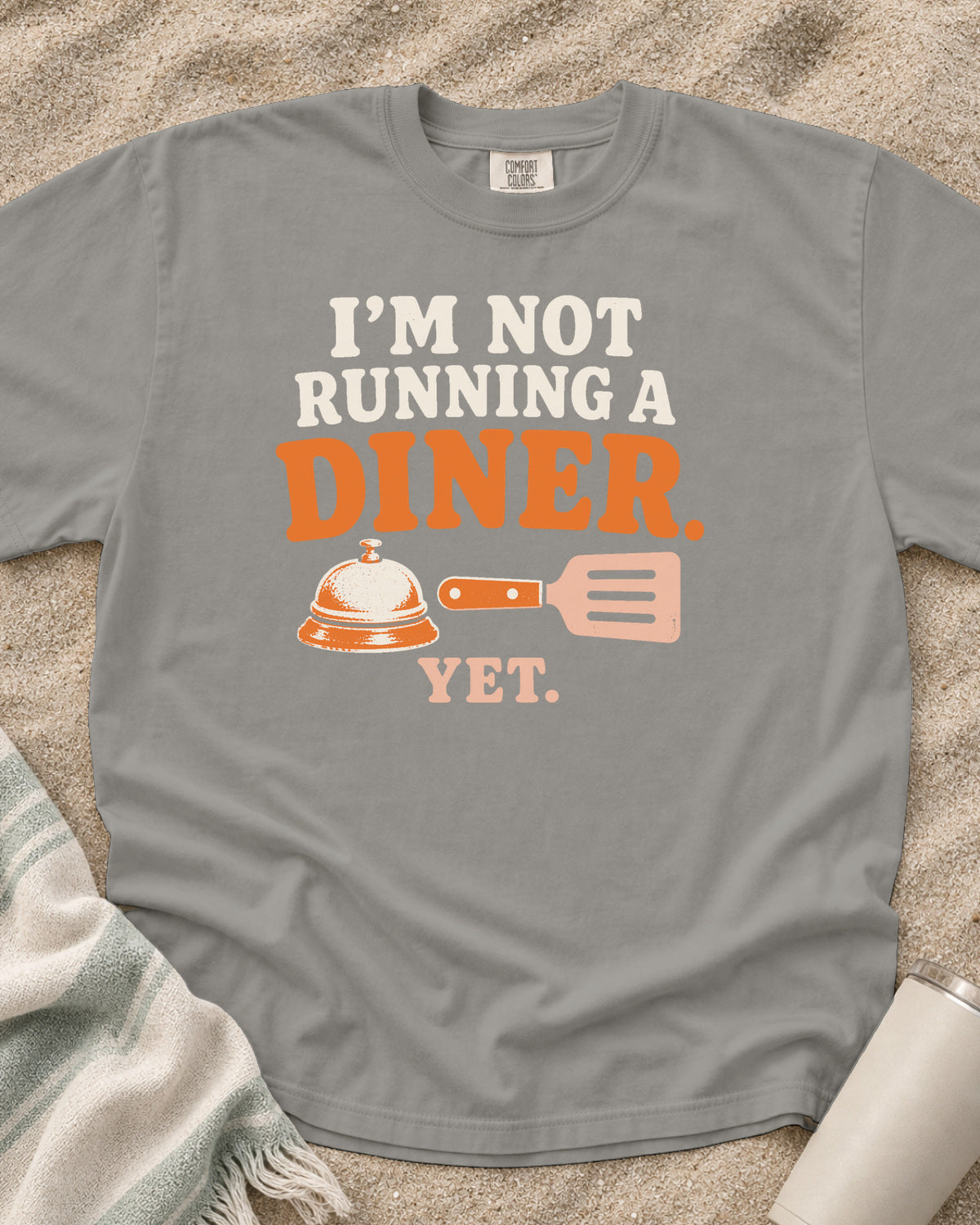 Grey garment-dyed tee with I’m Not Running a Diner Yet griddle graphic.