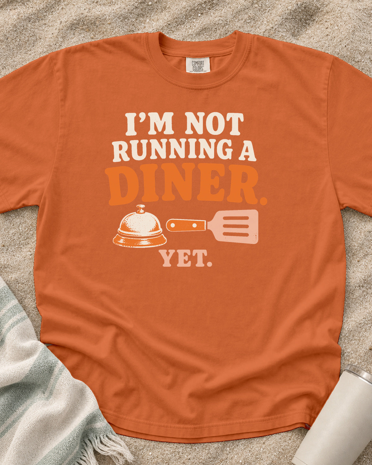 Burnt Orange garment-dyed tee with I’m Not Running a Diner Yet griddle graphic.