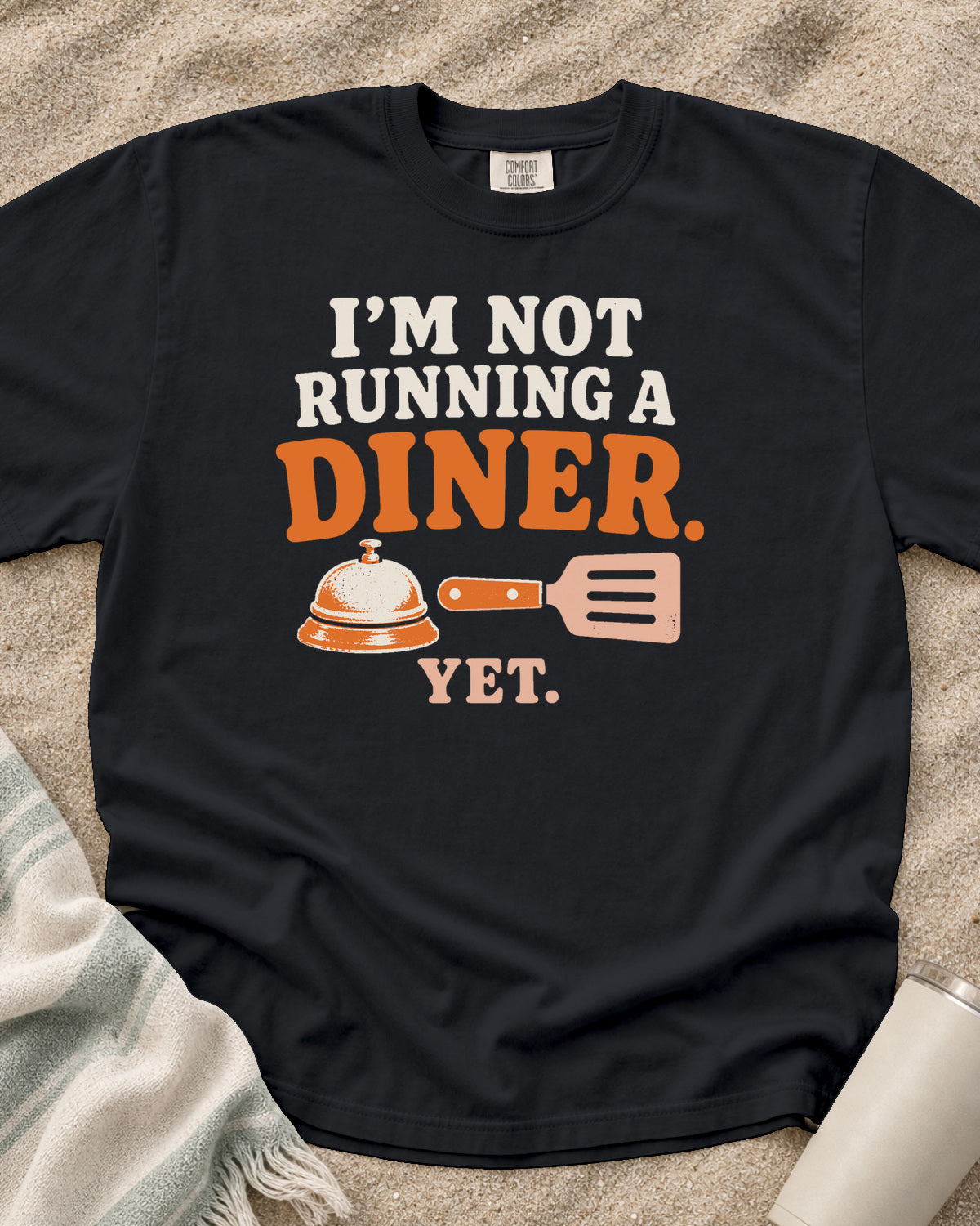 Graphite garment-dyed tee with I’m Not Running a Diner Yet griddle graphic.