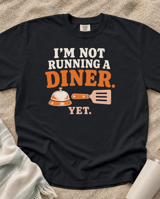 Graphite garment-dyed tee with I’m Not Running a Diner Yet griddle graphic.