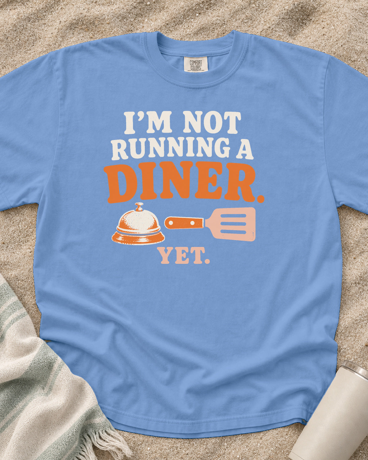 Washed Denim garment-dyed tee with I’m Not Running a Diner Yet griddle graphic.