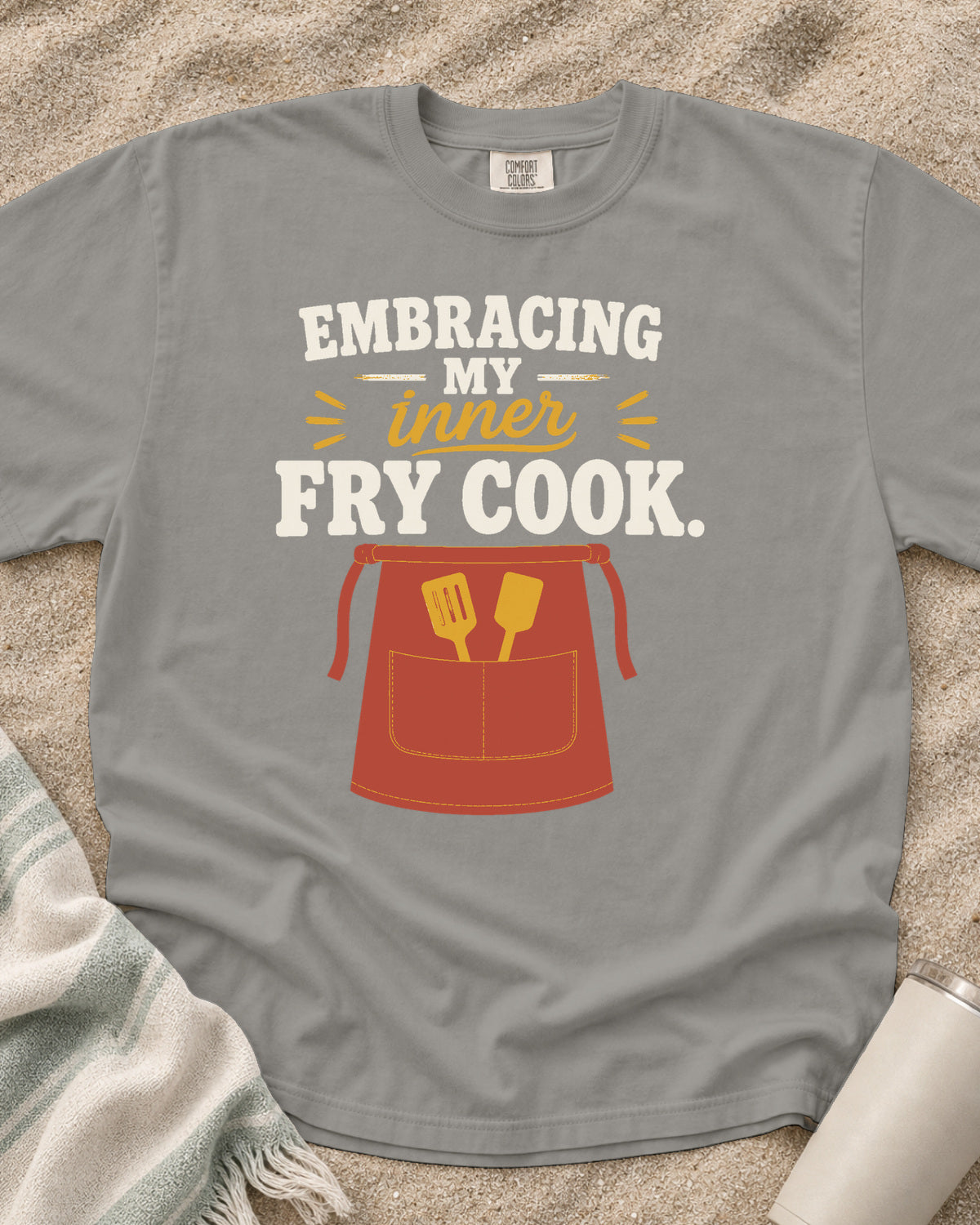 Grey garment-dyed tee with Embracing My Inner Fry Cook griddle graphic.