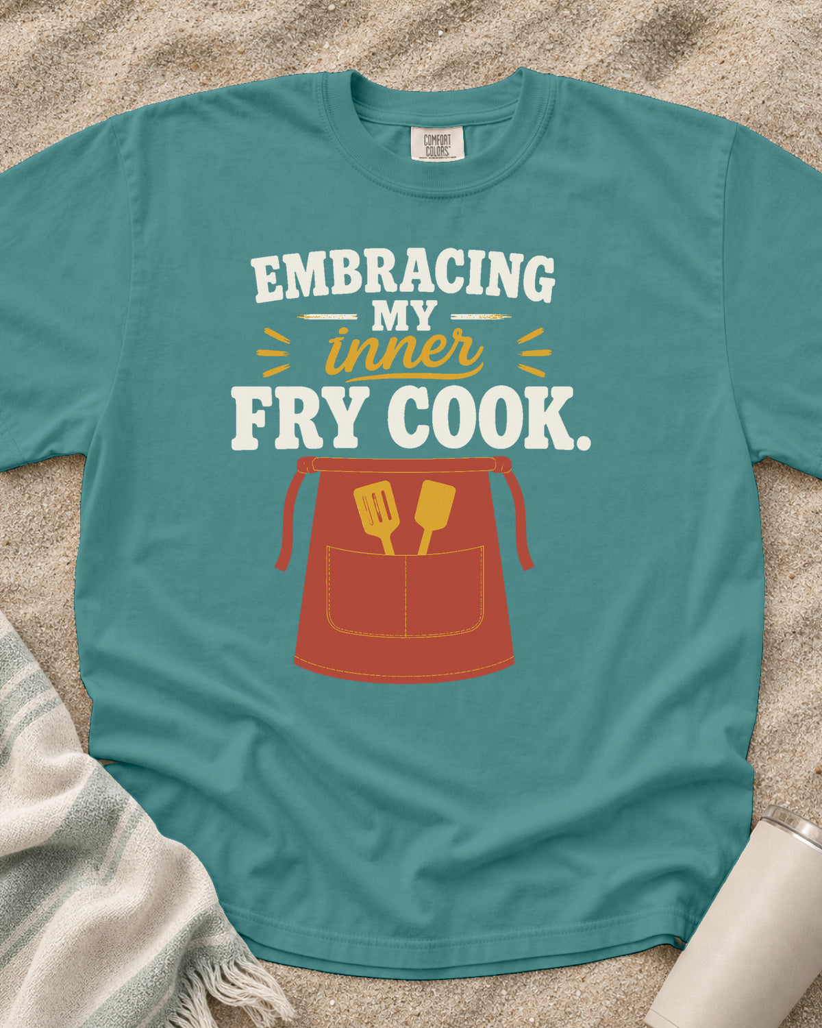 Seafoam garment-dyed tee with Embracing My Inner Fry Cook griddle graphic.