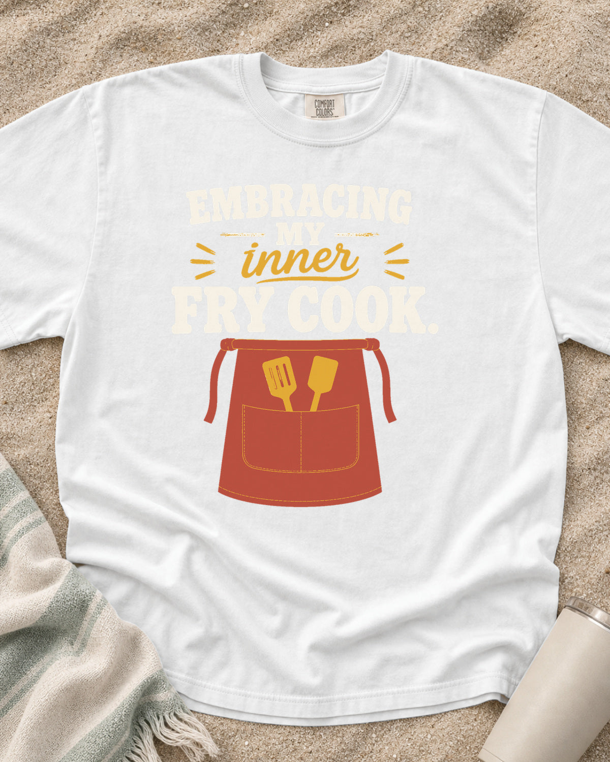 White garment-dyed tee with Embracing My Inner Fry Cook griddle graphic.