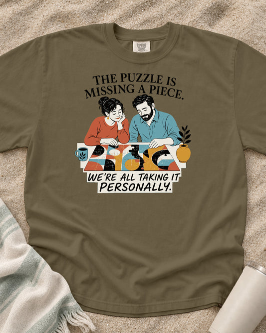 Khaki Comfort Colors 1717 tee with The Puzzle Is Missing a Piece. We're All Taking It Personally graphic.